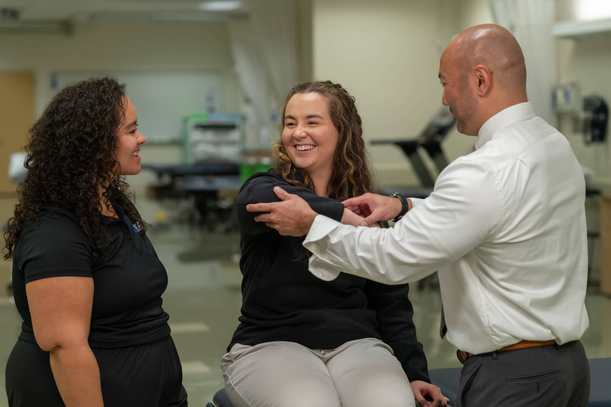 A faculty member demonstrates an adjustment technique on a student